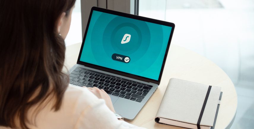 A woman sitting at a desk, connecting to a VPN on her laptop.