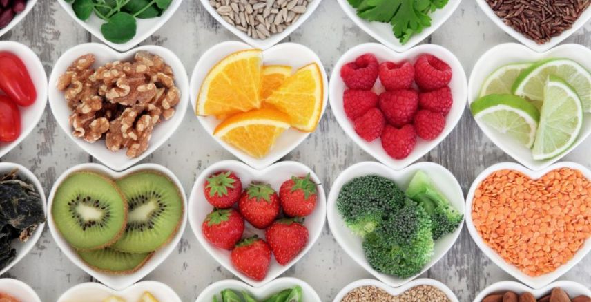 Different fruits and vegetables in small white dishes.