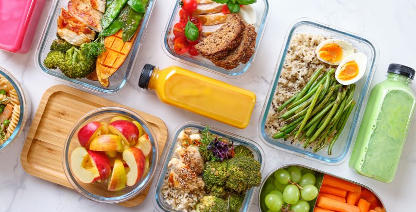 Containers of healthy foods, meal prep, and bottles of fresh juice.
