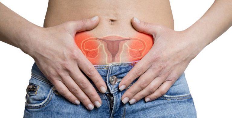 A woman with her hands on her abdomen. There is a digital drawing of female reproductive organs overtop of her body.